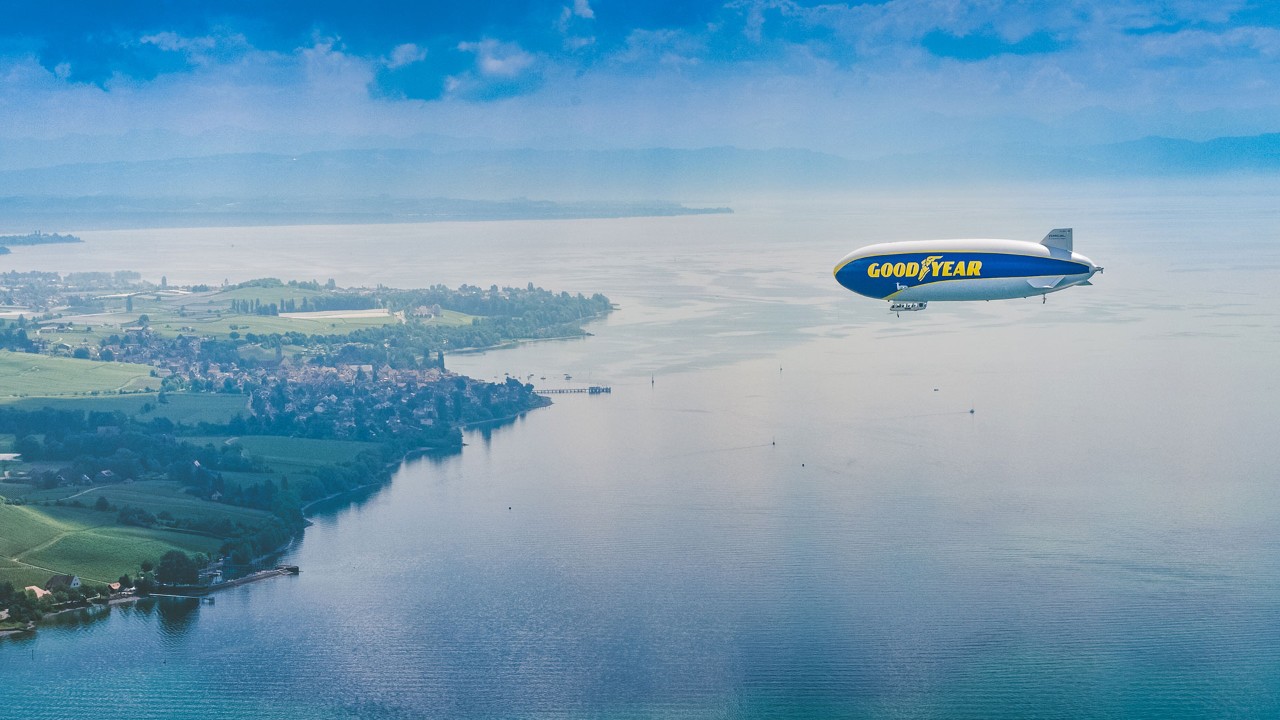 Image of Goodyear Blimp flying over water towards Europe
