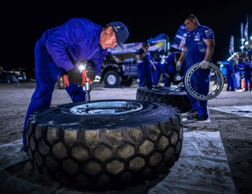 Operator mounting truck tyre for Dakar